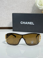Sunglasses with brown-tinted lenses, gold frame, classic geometric temple detail