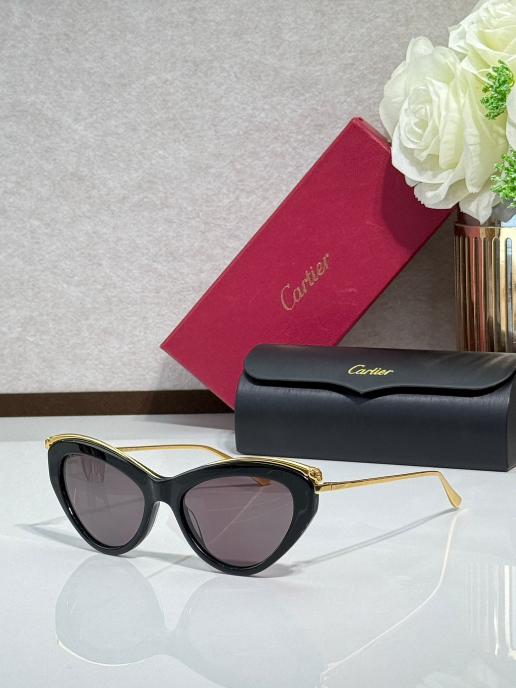 Black sunglasses with gold-tone rims and dark tinted lenses