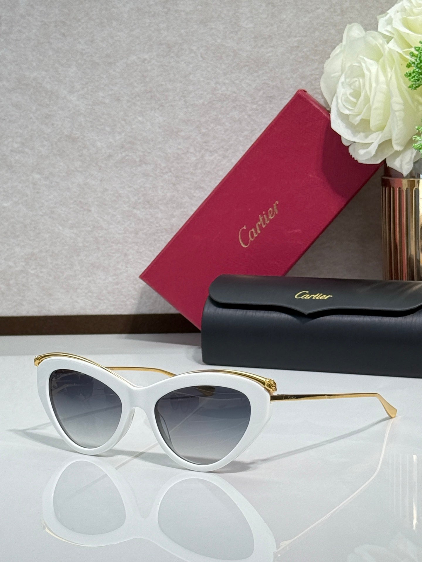 White sunglasses with gold-tone temples and dark tinted lenses