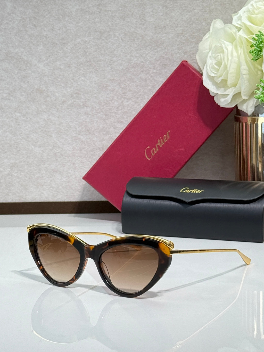 Black sunglasses with gold-tone temples and warm brown tinted lenses