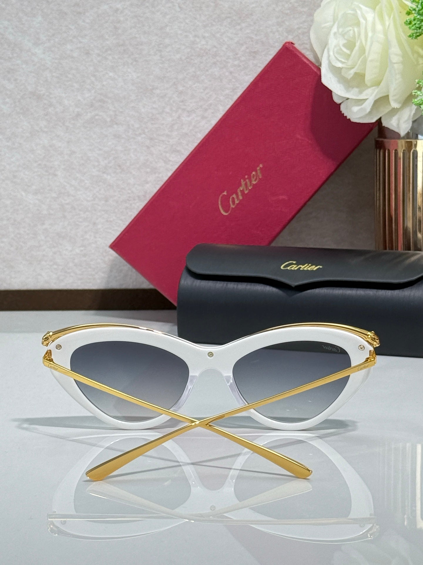 White sunglasses with gold-tone rims and dark tinted lenses
