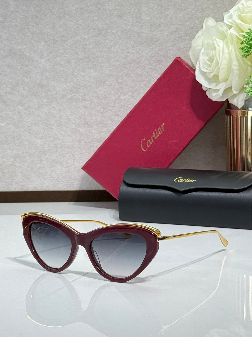 Burgundy sunglasses with gold-tone temples and dark tinted lenses
