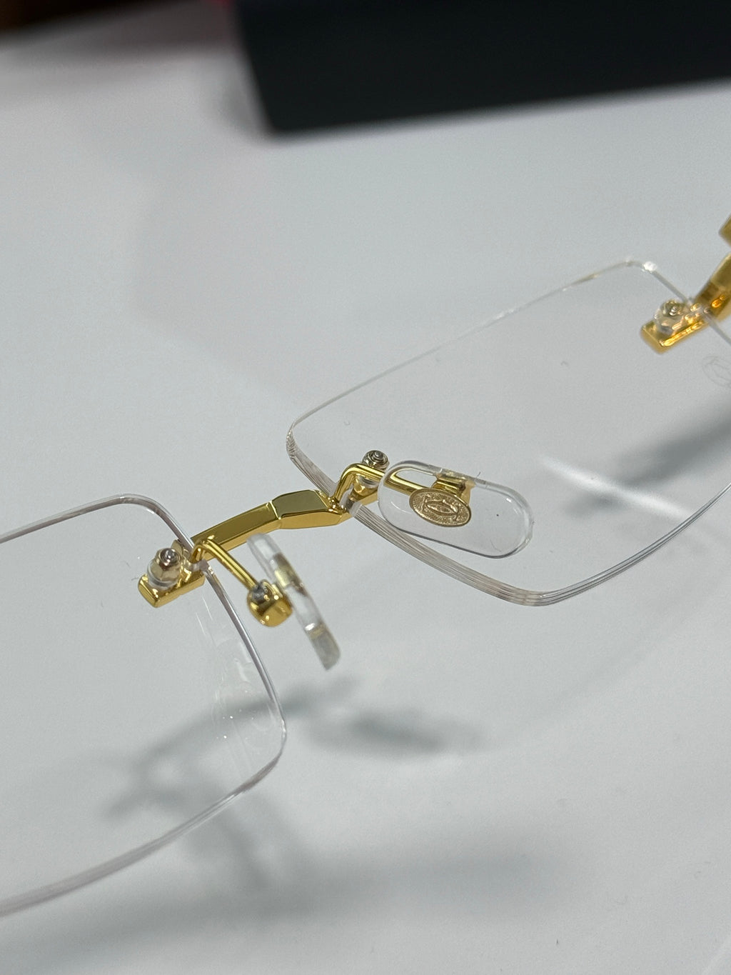 Gold metal eyeglasses with clear lenses and hinge details