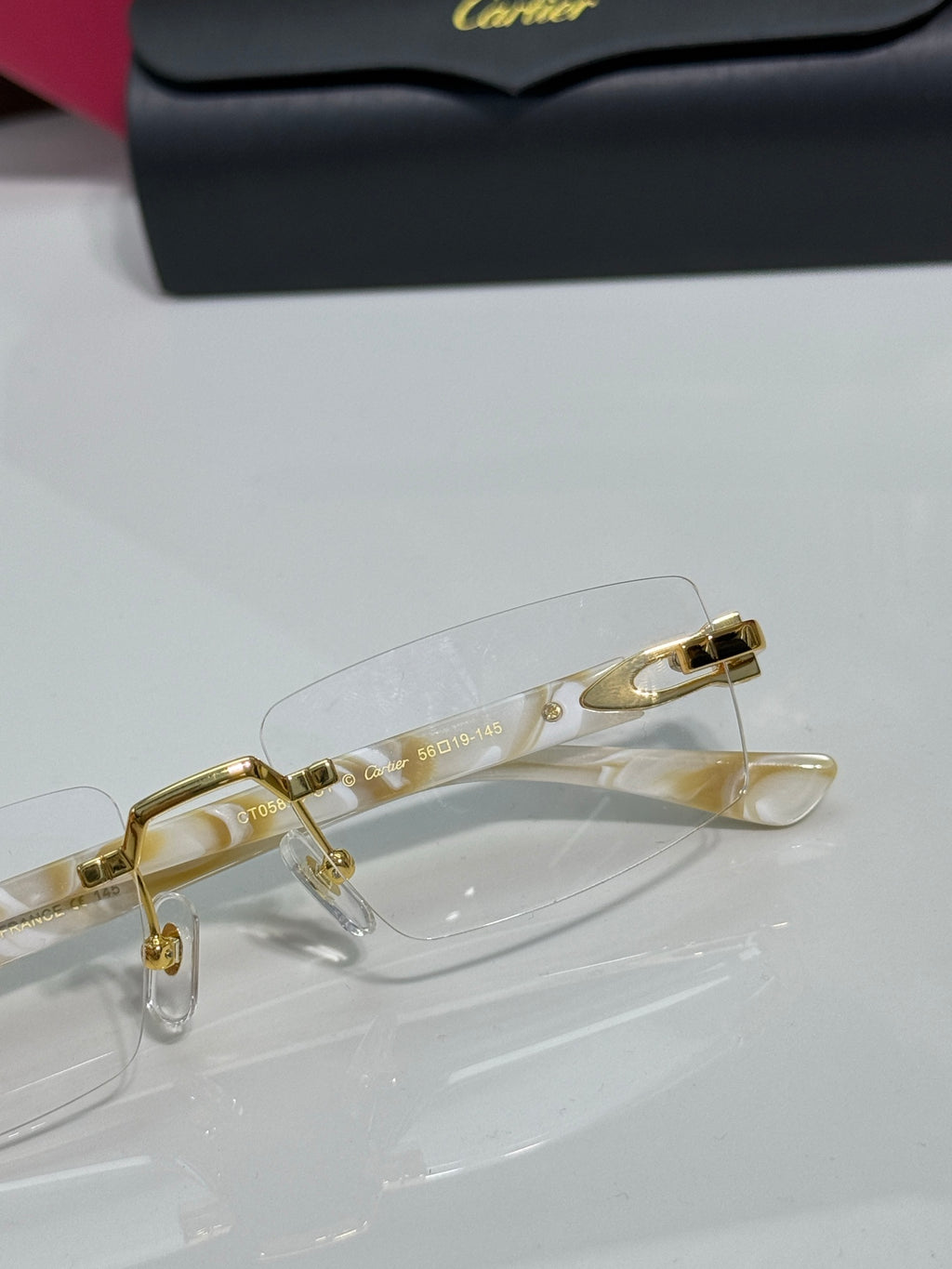 Clear eyeglasses with gold frame and temple accents, front close-up