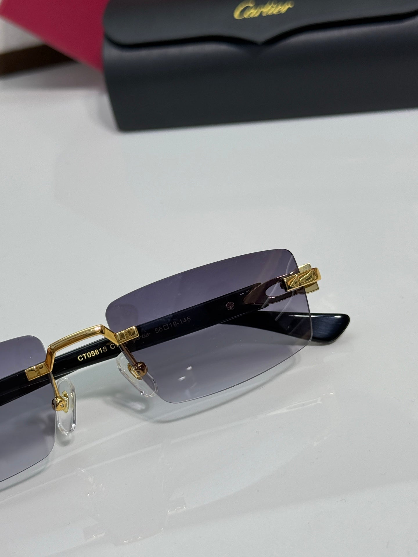 Cartier eyeglasses close-up with dark purple lenses and gold-tone bridge hardware