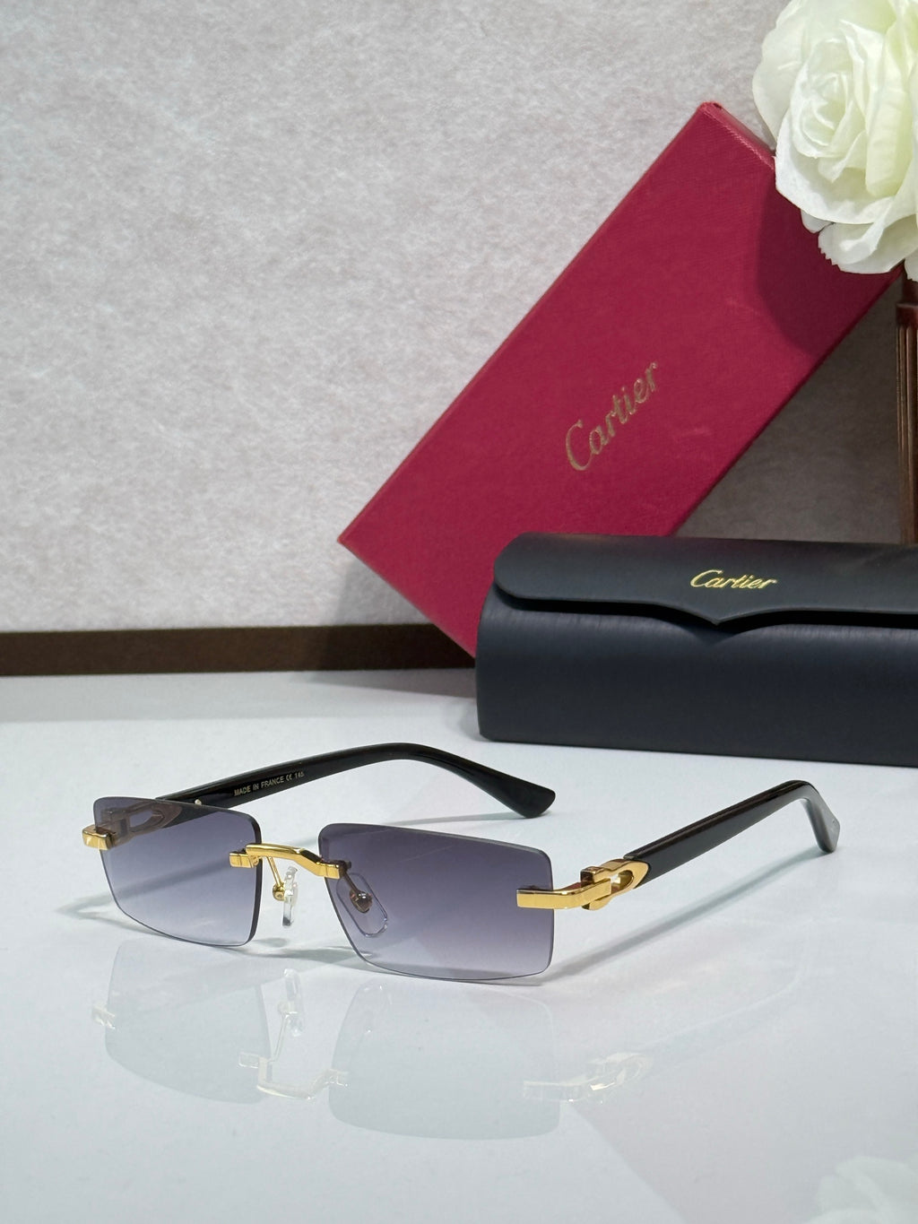 Cartier eyeglasses with light blue-tinted lenses, pale frames, and gold-tone details