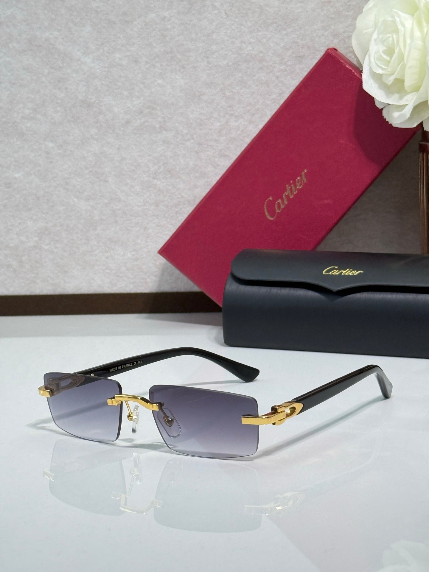 Cartier eyeglasses with light blue-tinted lenses, pale frames, and gold-tone details
