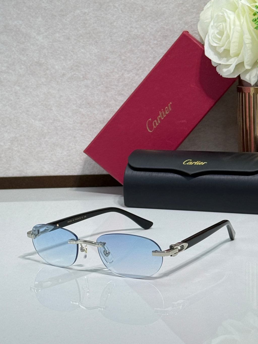 Cartier eyeglasses with light blue lenses, gold accents, and dark temple arms