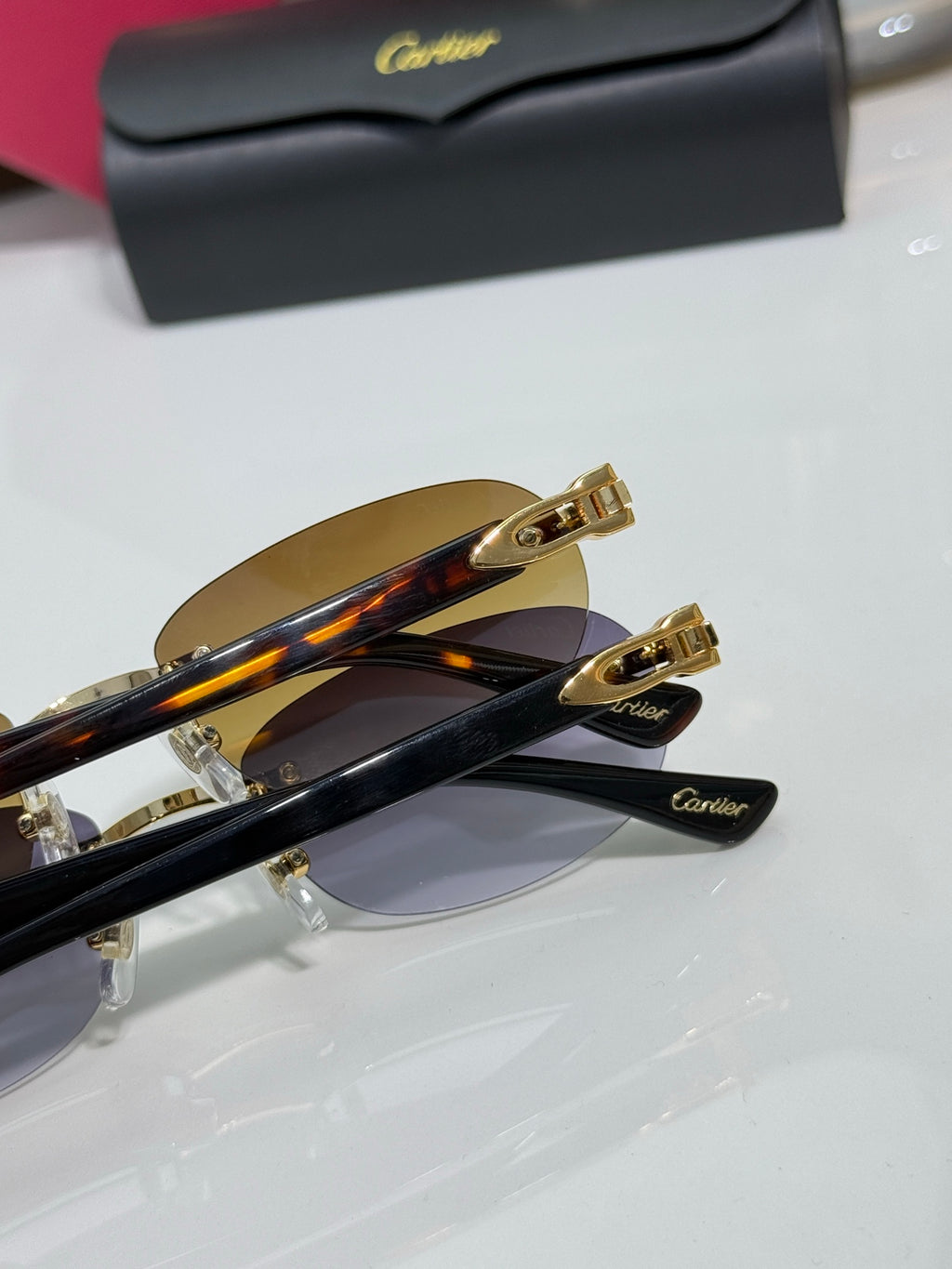 Cartier eyeglasses close-up: gold frame hardware, tinted lens, dark temple arms