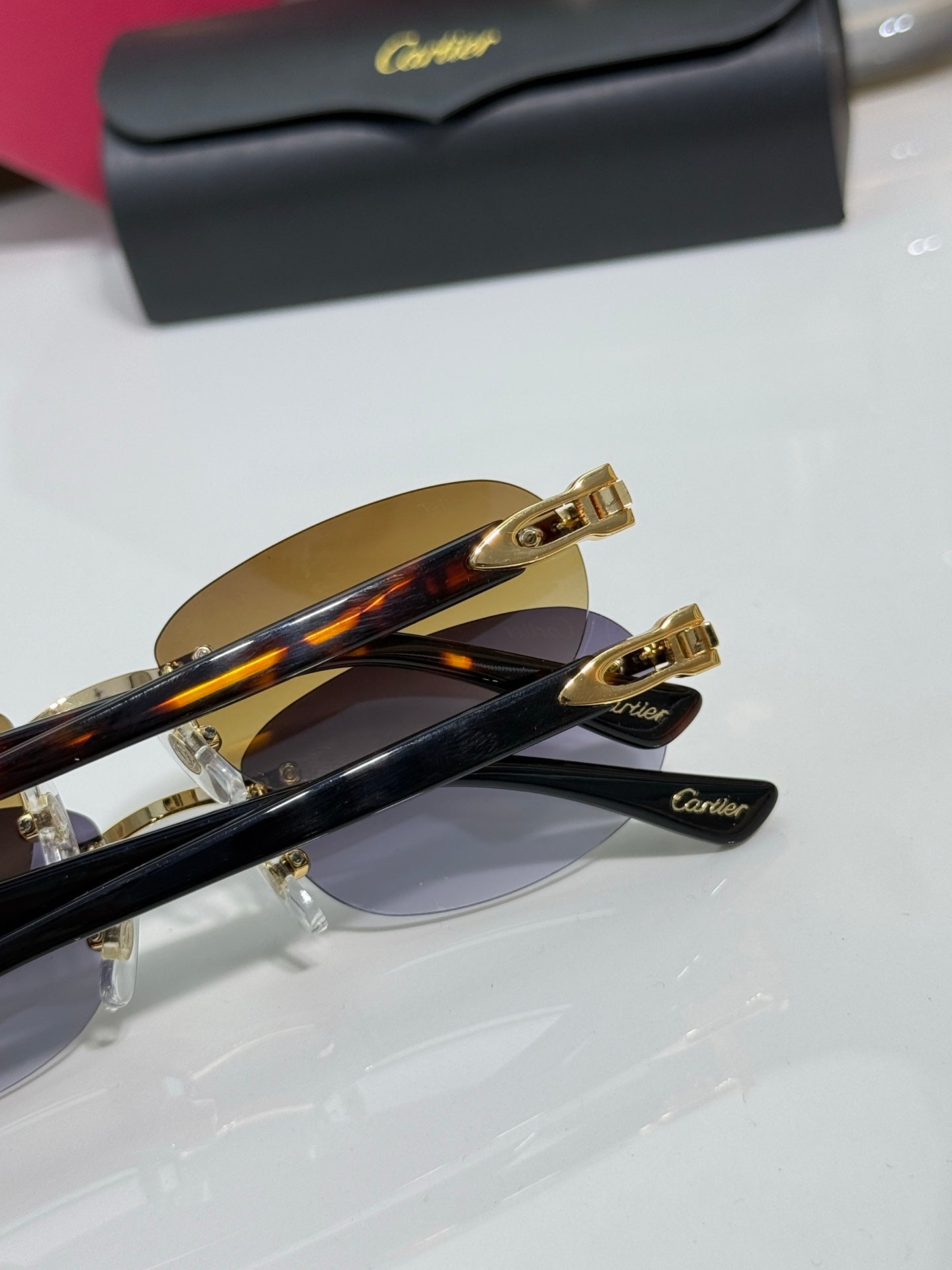 Cartier eyeglasses close-up: gold frame hardware, tinted lens, dark temple arms