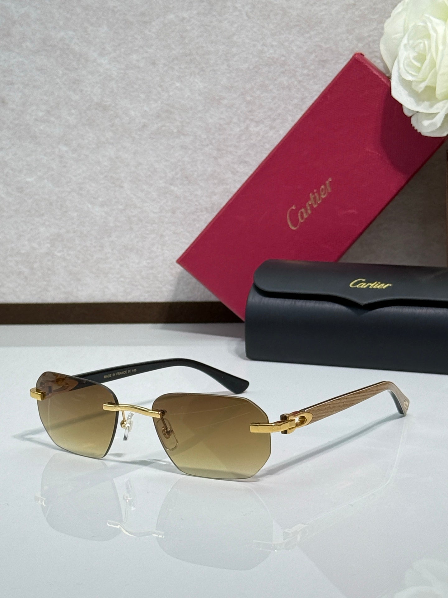Cartier glasses with tortoiseshell frame, gold details, and amber tinted lenses
