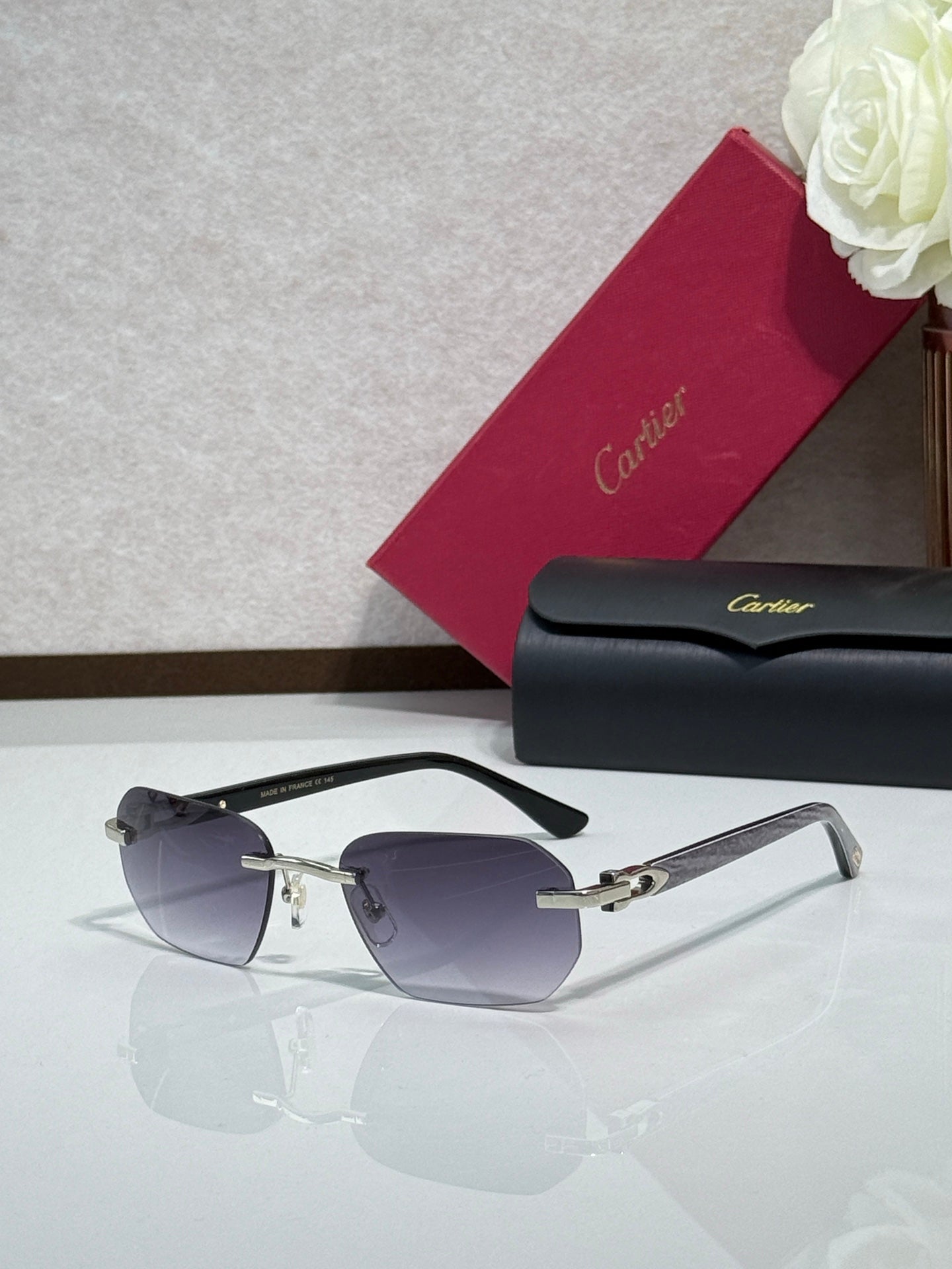 Cartier glasses with dark tinted lenses and black frame with gold accents