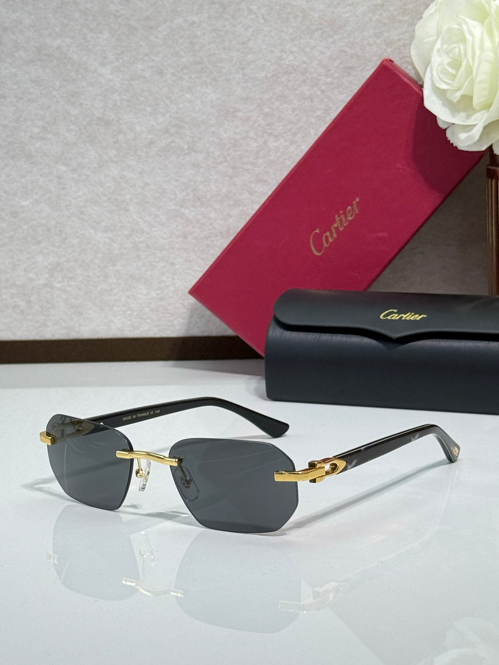 Cartier glasses with black frame, gold details, and dark tinted lenses