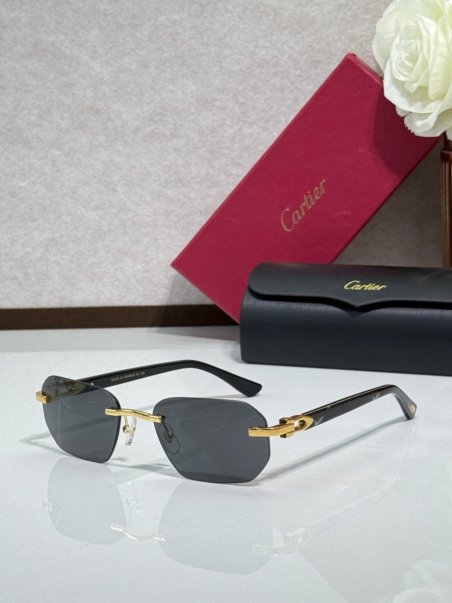 Cartier glasses with black frame, gold details, and dark tinted lenses