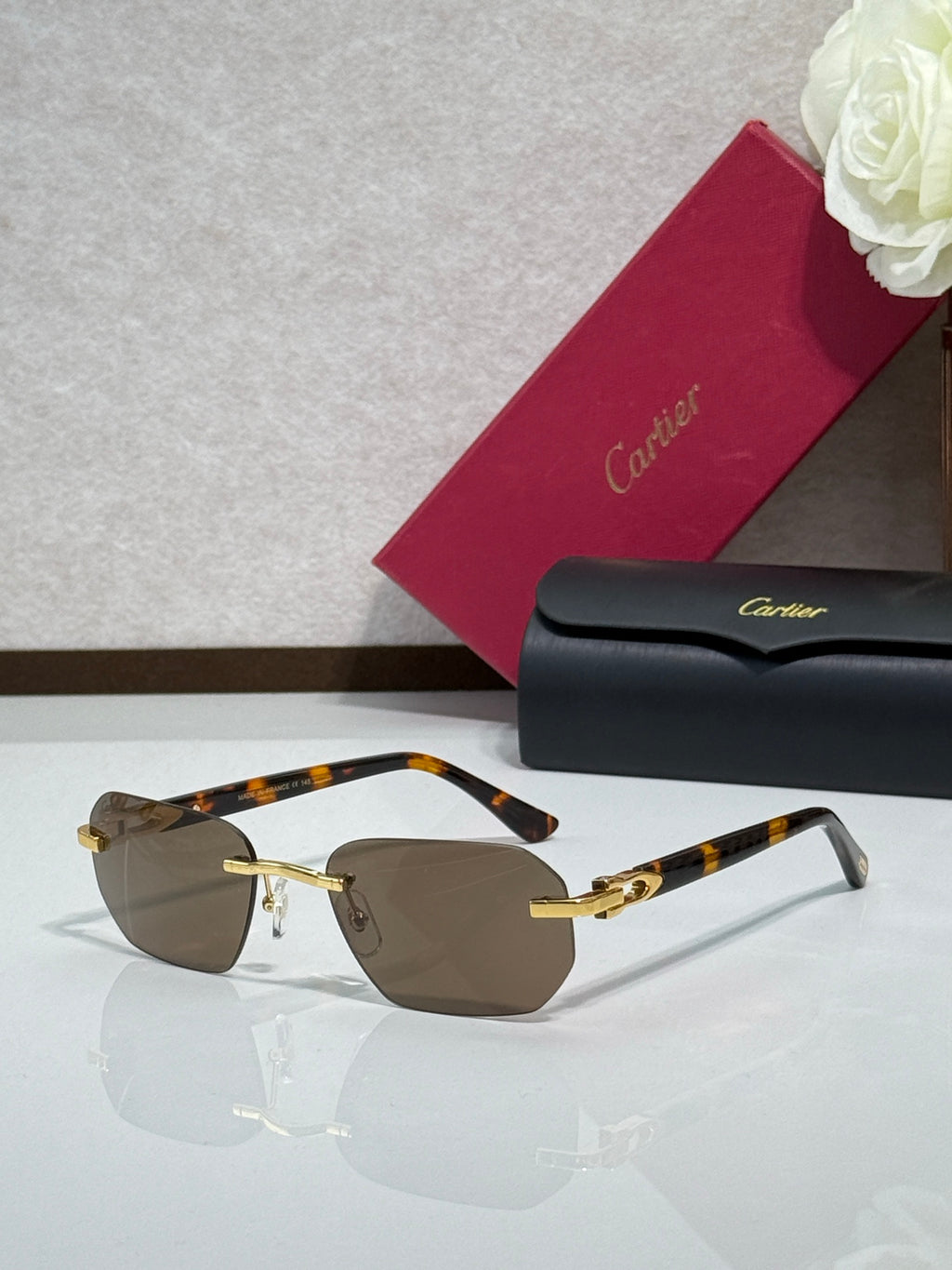 Cartier glasses with tortoiseshell frame, gold accents, and brown tinted lenses