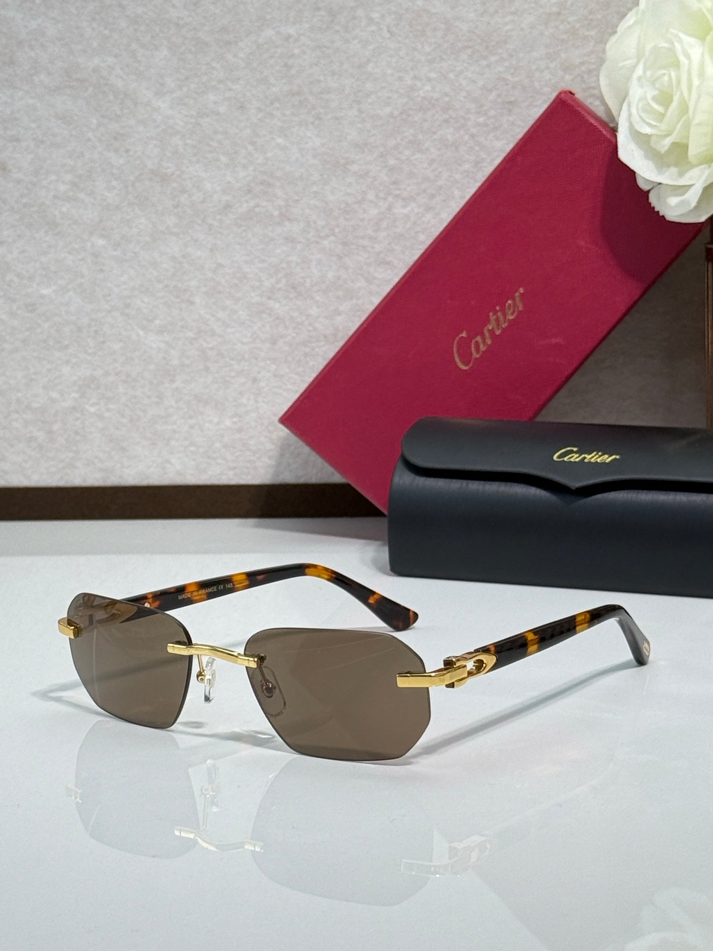Cartier glasses with tortoiseshell frame, gold accents, and brown tinted lenses