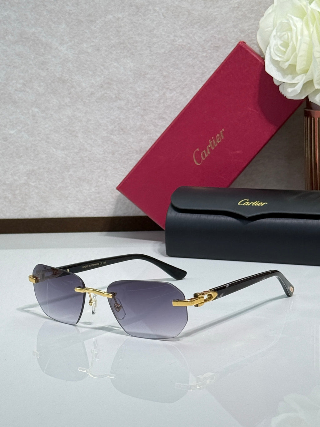 Cartier glasses with black frame, gold hinges, and dark tinted lenses