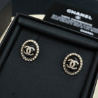 Round stud earrings with black enamel CC logo and crystal halo, gold-tone backs