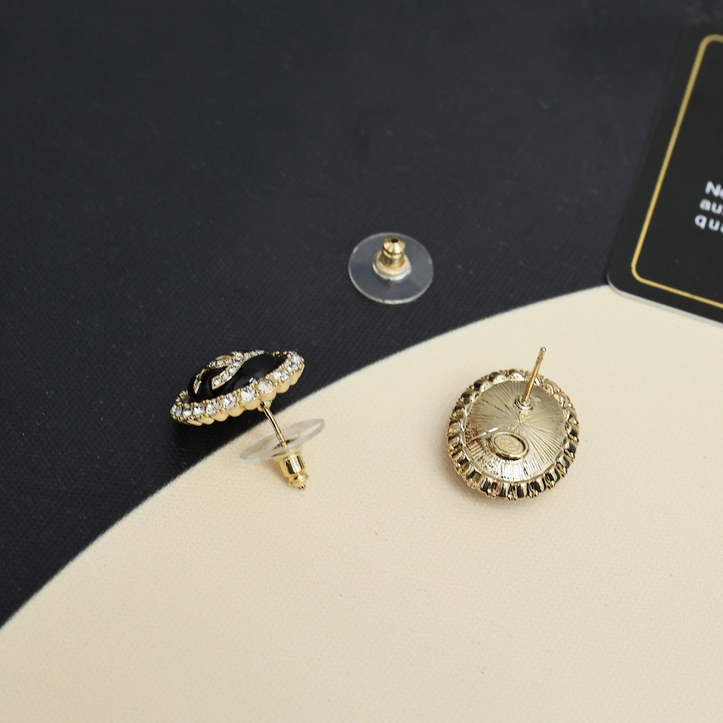 Chanel CC stud earrings with black-and-gold circular crystal edges and gold-tone posts