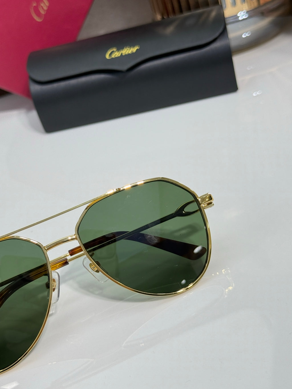 Cartier round sunglasses close-up with green lenses and gold rim