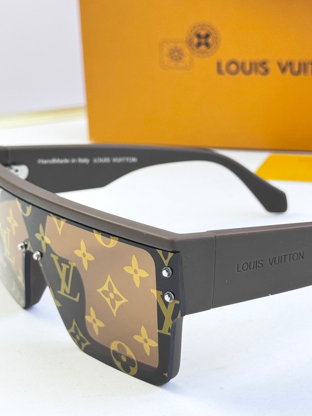 Louis Vuitton sunglasses close-up side view, dark blue monogram frame with metal rivets