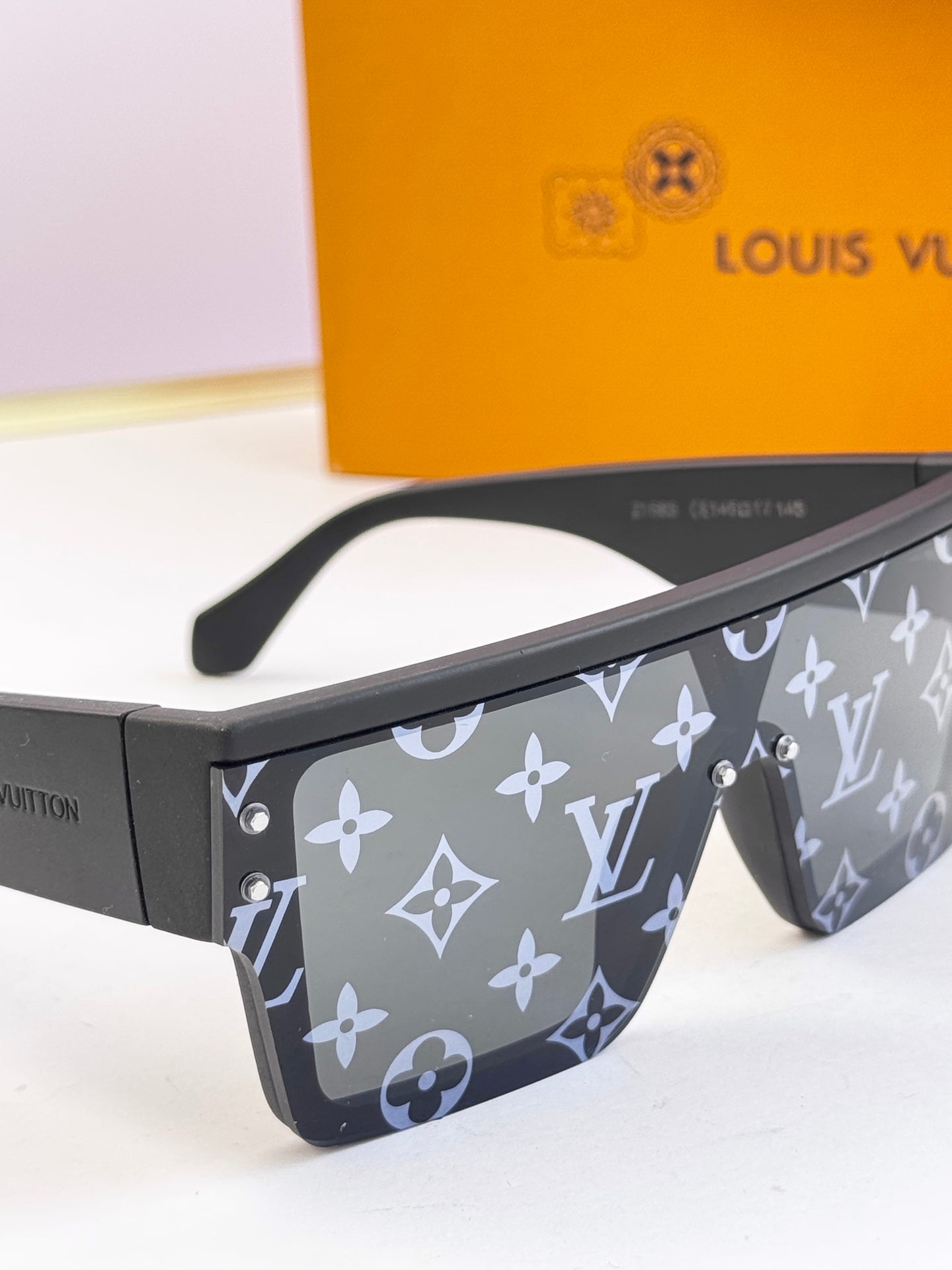 Louis Vuitton sunglasses close-up: dark blue monogram panels with metal studs and hinges