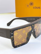 Louis Vuitton sunglasses side view, dark frame with gold monogram pattern and clear lenses