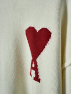 Cream knit sweater with red heart graphic on the chest