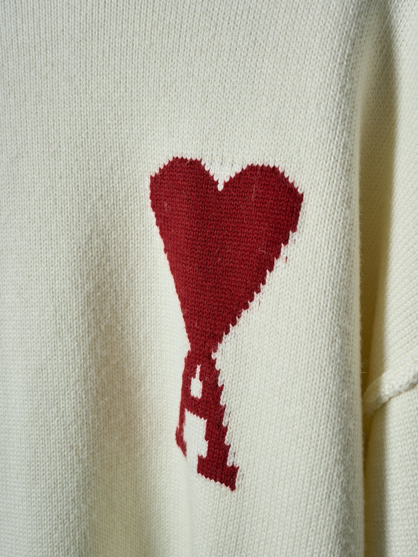 Cream knit sweater with red heart graphic on the chest