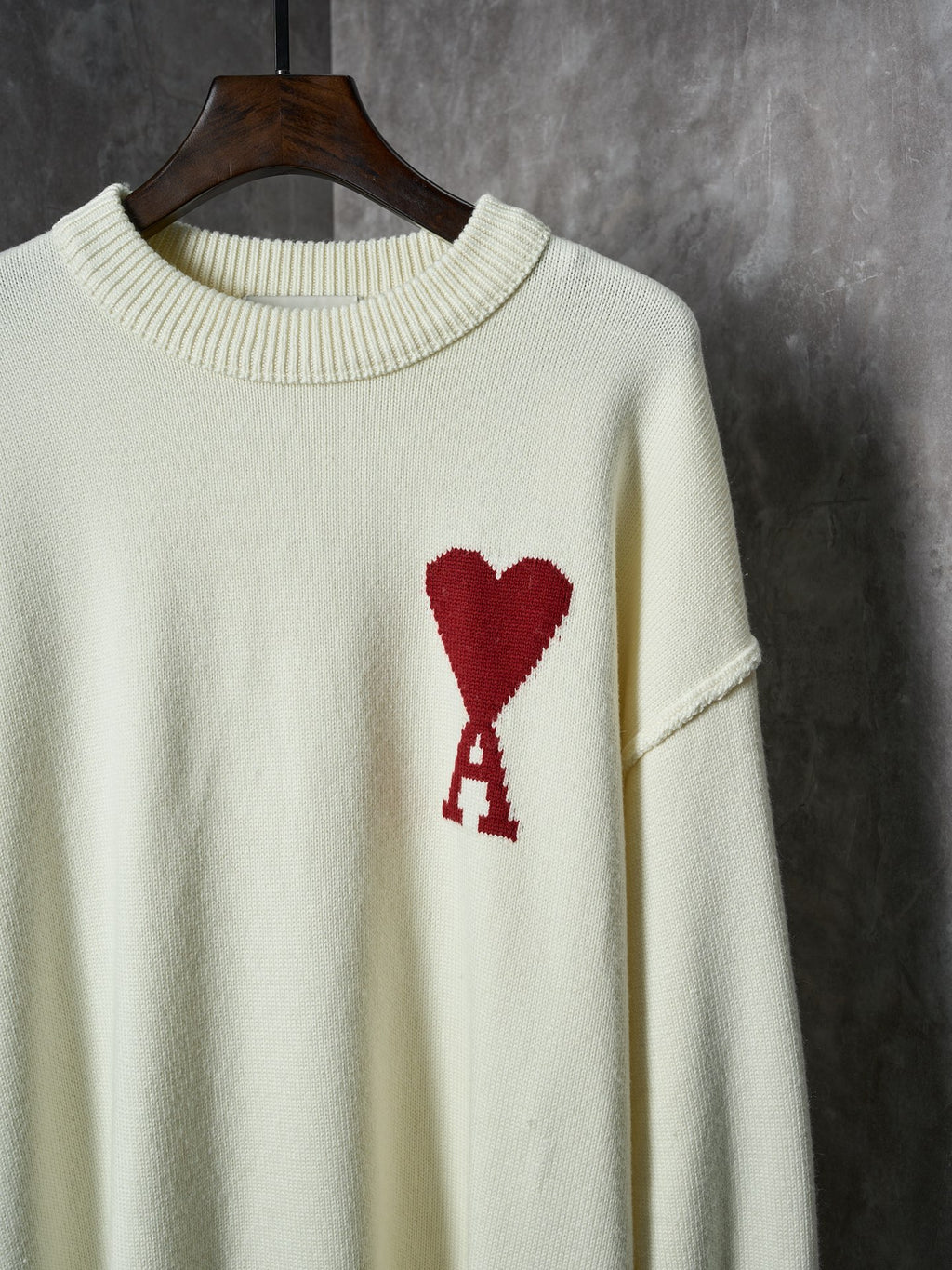 Cream knit sweater chest detail with red heart and red A appliqué