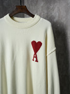 Cream knit sweater chest detail with red heart and red A appliqué