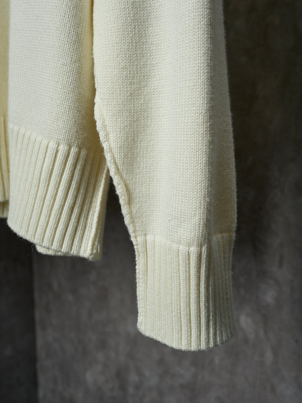 Cream knit sweater sleeve cuff and ribbed hem detail