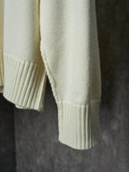 Cream knit sweater sleeve cuff and ribbed hem detail