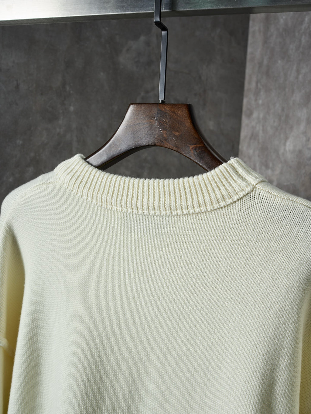 Cream knit sweater with ribbed crew neck on the back, collar close-up