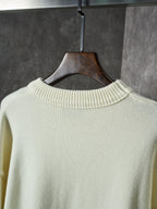 Cream knit sweater with ribbed crew neck on the back, collar close-up