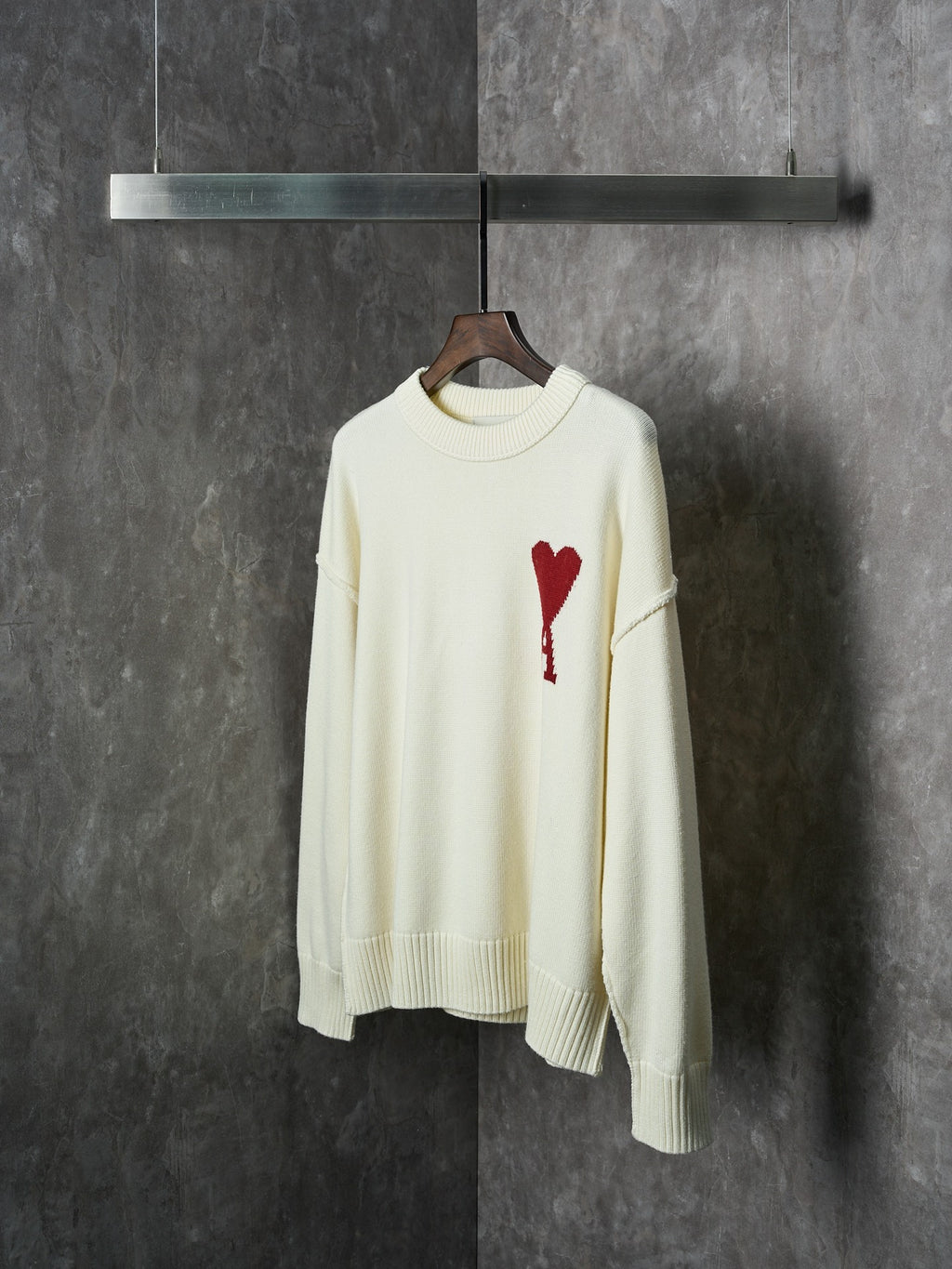 Cream knit sweater with red heart-and-A appliqué on the chest, full front view