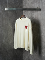 Cream knit sweater with red heart-and-A appliqué on the chest, full front view
