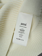 Cream knit sweater with attached interior brand label reading “ami”
