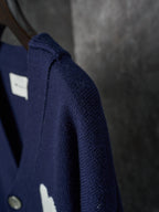 Side view of navy knit cardigan with ribbed shoulder seam and button placket detail