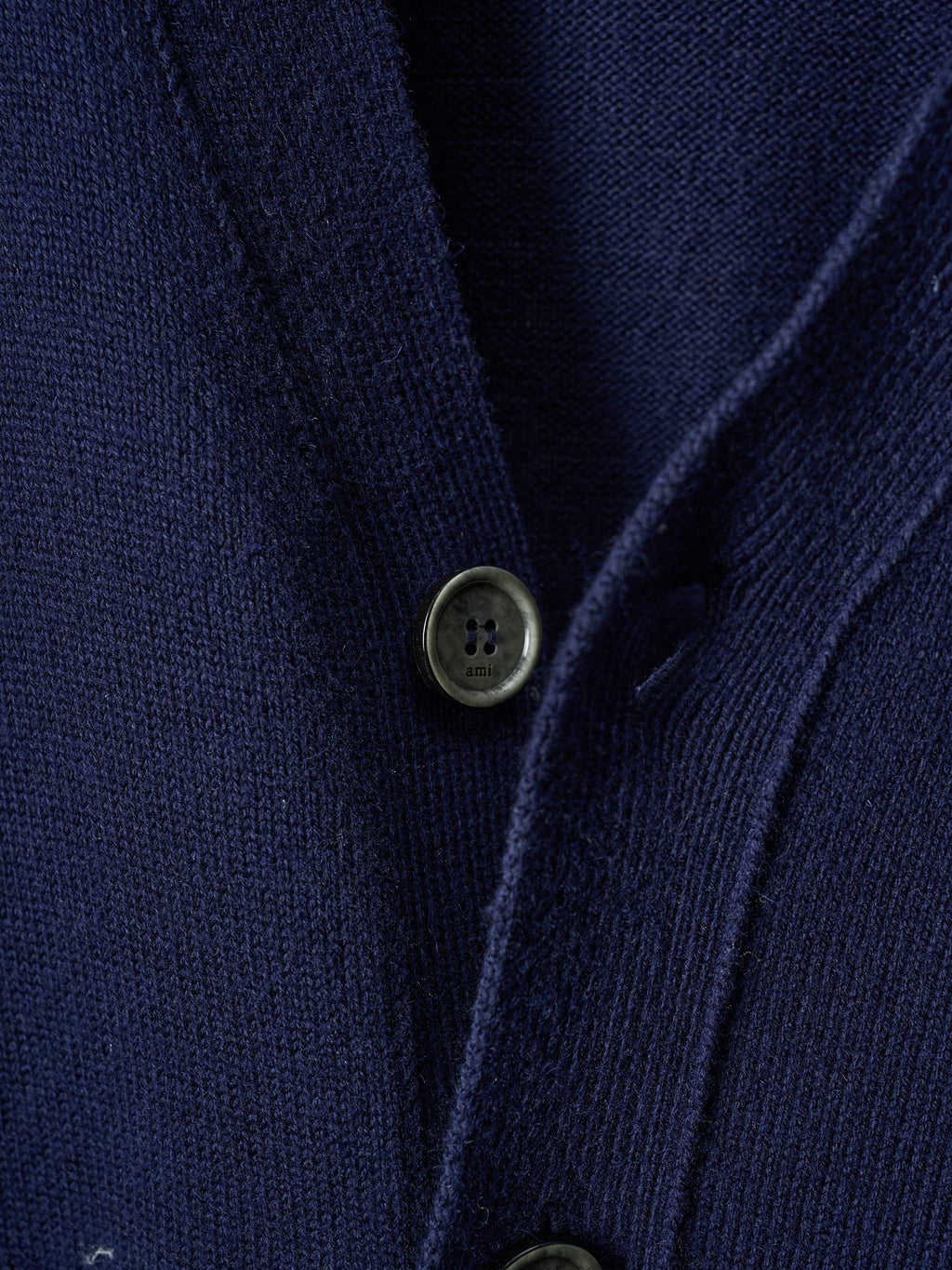 Navy knit cardigan close-up of button front with two dark olive-toned buttons