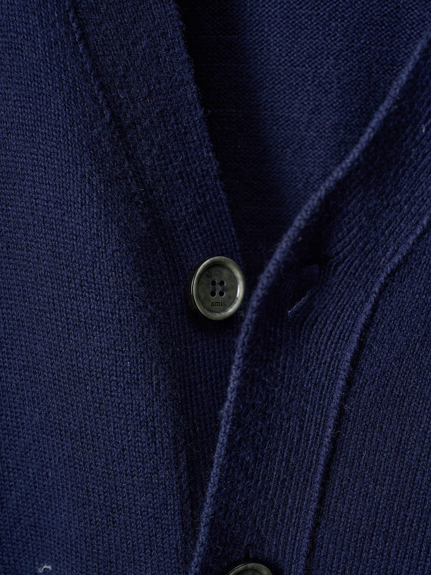 Navy knit cardigan close-up of button front with two dark olive-toned buttons