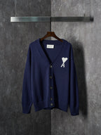 Navy knit cardigan with V-neck, button front, and white A heart emblem on chest