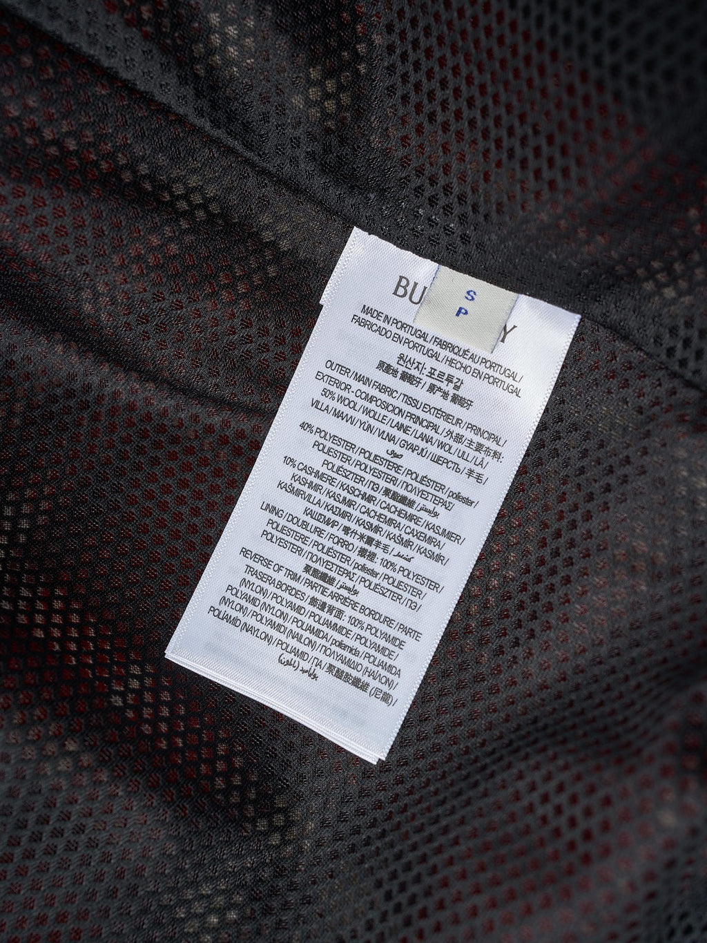Long clothing label on dark patterned fabric