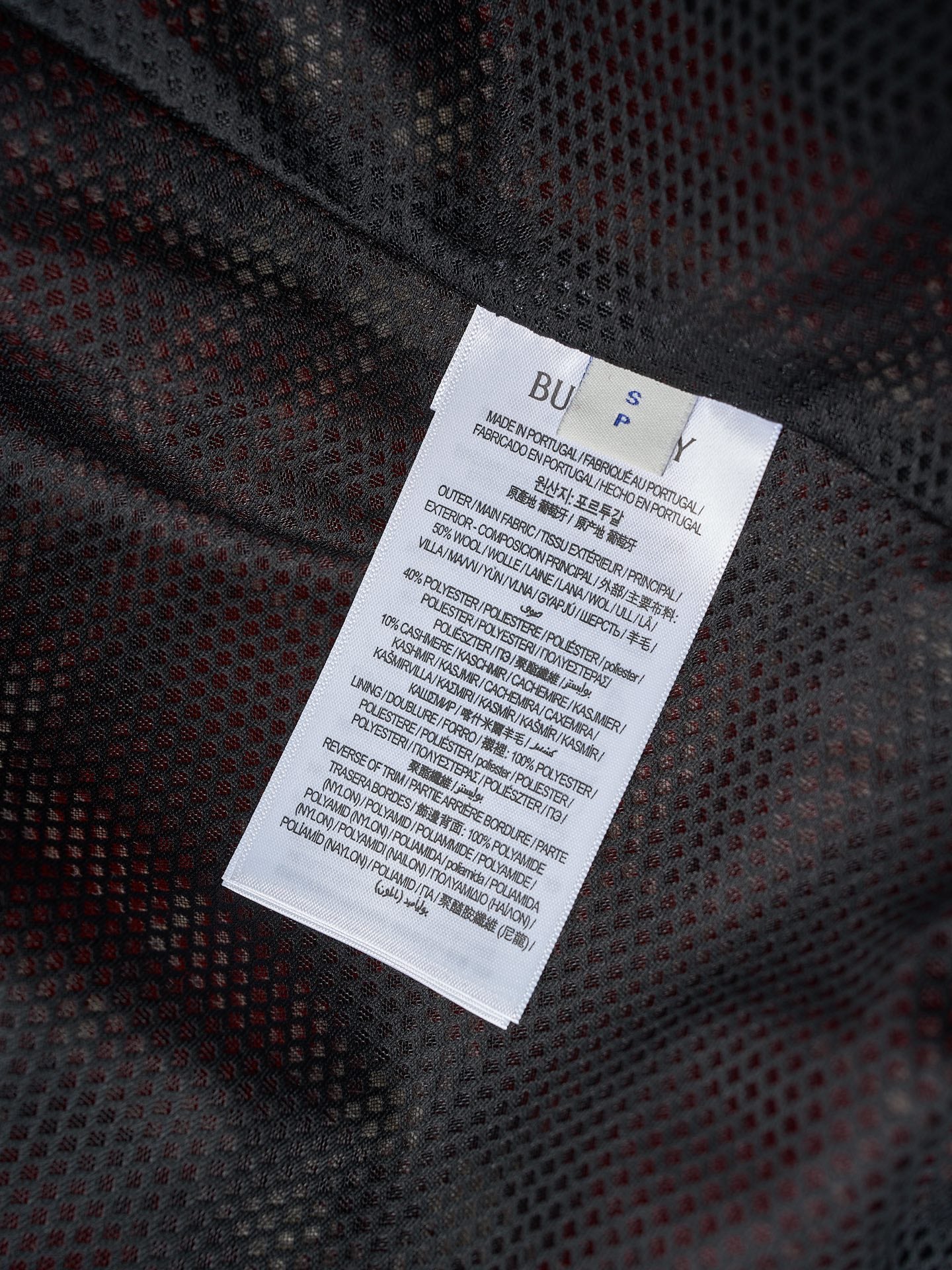 Long clothing label on dark patterned fabric
