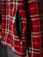 Red plaid jacket front with black zip and visible pocket seam