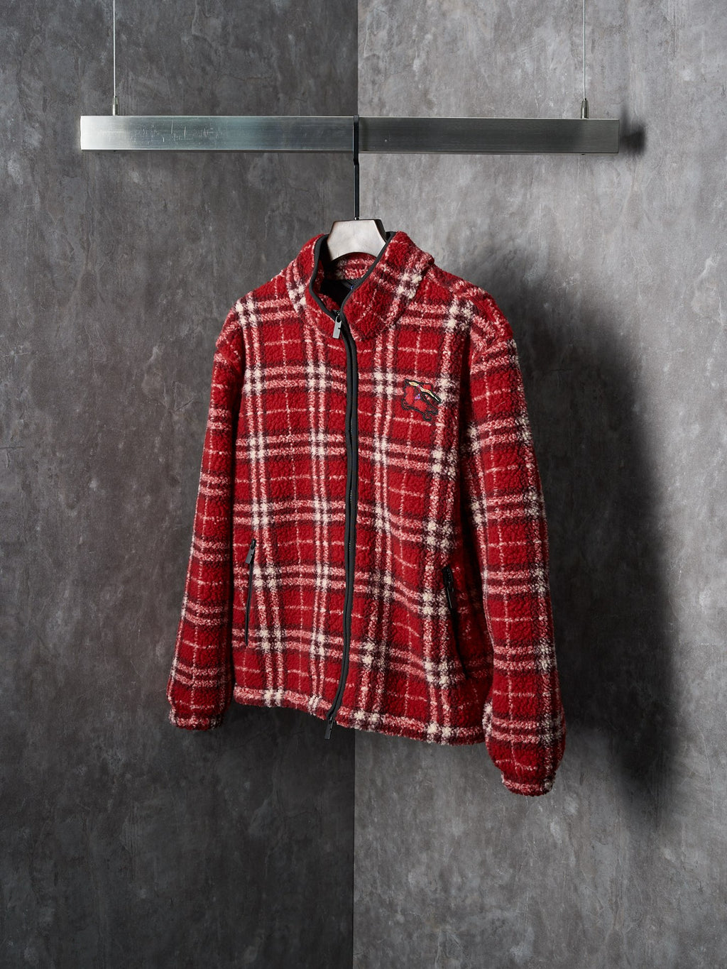 Red plaid zip-up jacket on hanger, side view