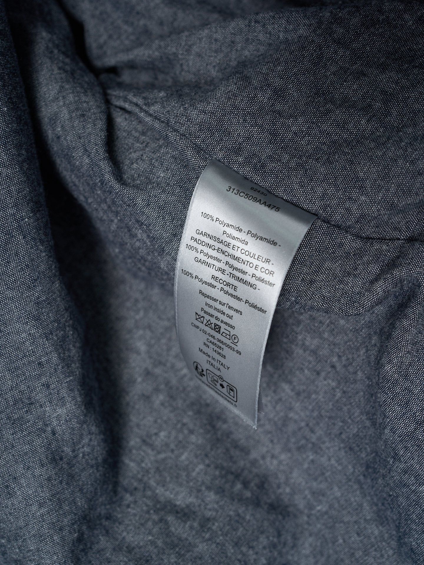Long garment fabric with inner care label on dark gray textile
