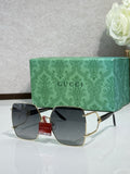 Gucci sunglasses with black lenses and gold frame, rectangular oversized shape