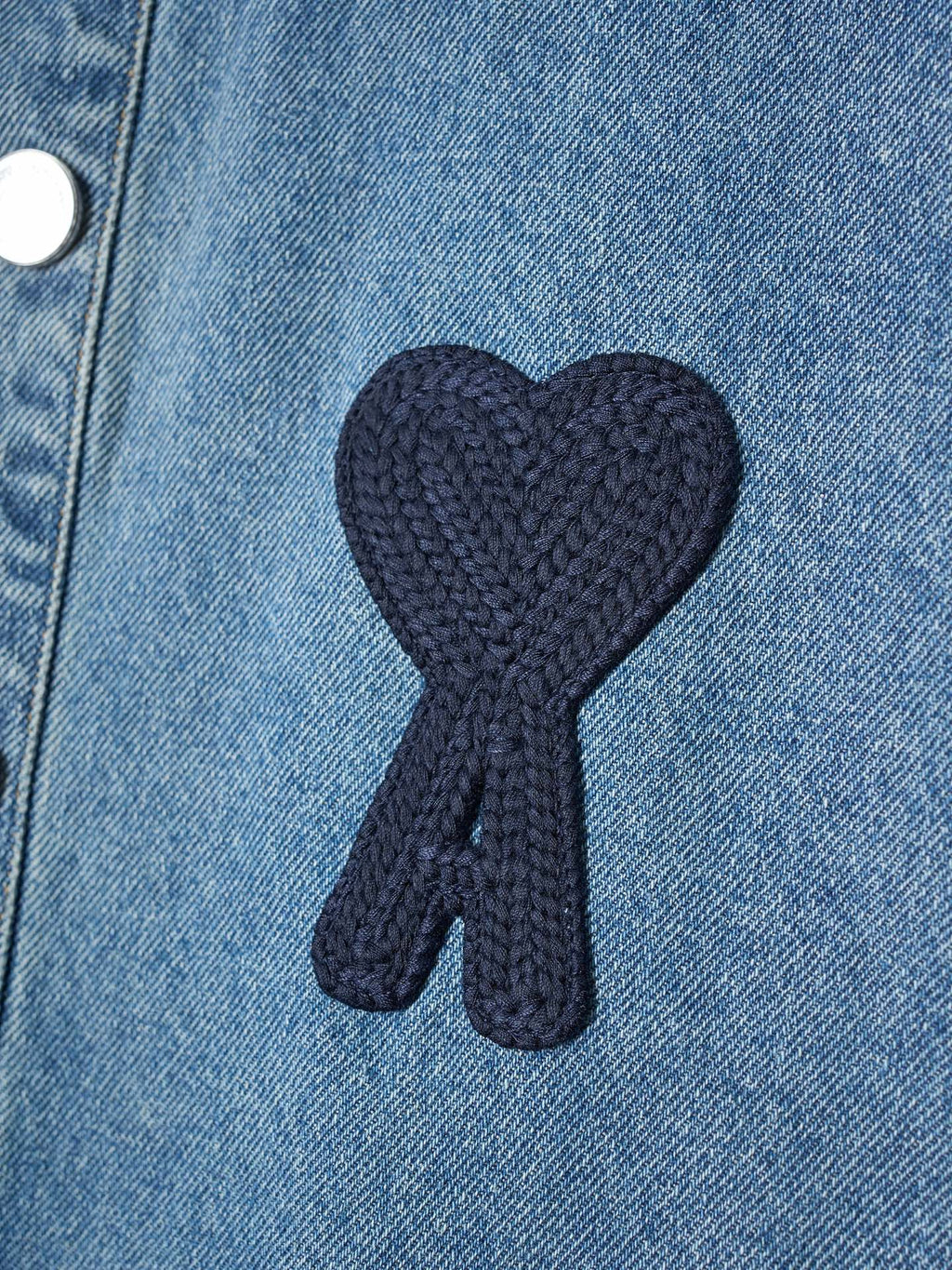 Dark knit heart-and-ribbon applique on light blue denim fabric