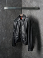 Dior black leather jacket with stand collar and front zipper closure, hanging
